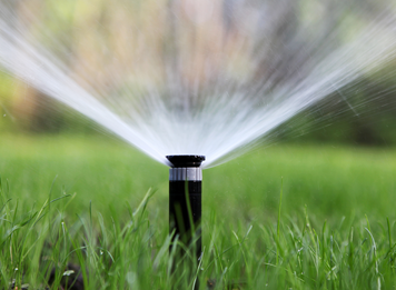 Sprinkler spraying water on lawn